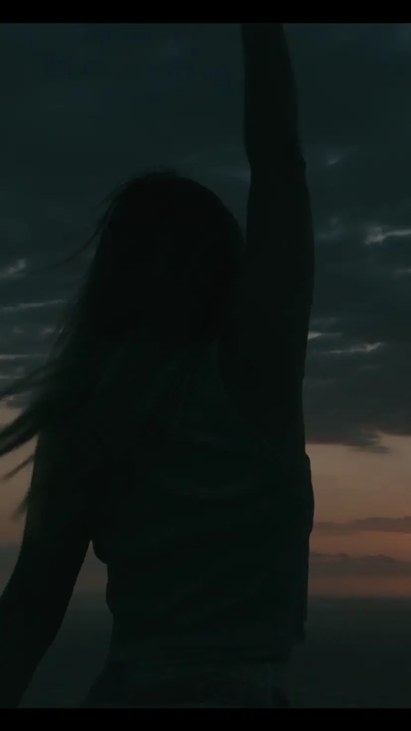 A dancer at dusk against the setting sun over the ocean — a still from the Midnight Dreaming film