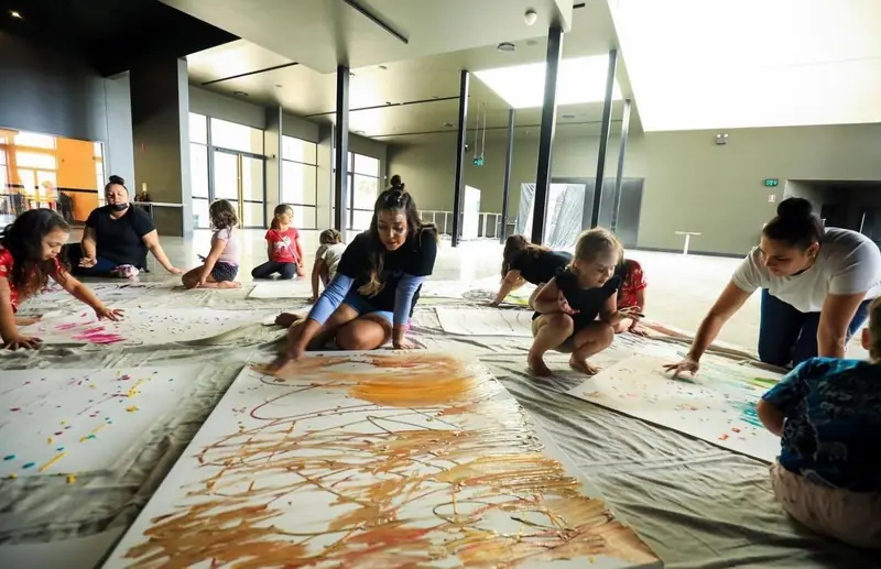 A collaborative ground mural under way at a community workshop